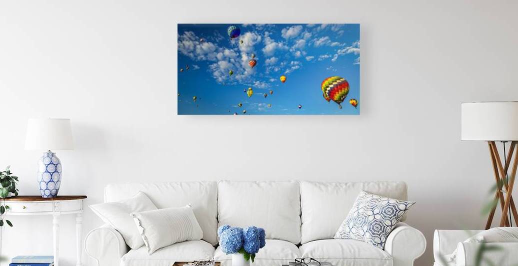 Colorful hot air balloons floating under a bright blue sky by Gestalt Imagery