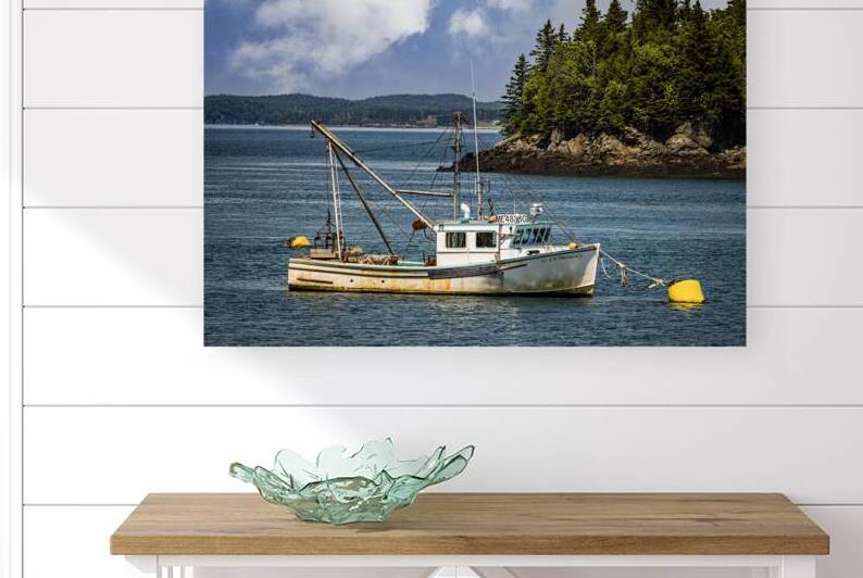 Fishing boat anchored by a scenic coastline featuring lush trees by Gestalt Imagery