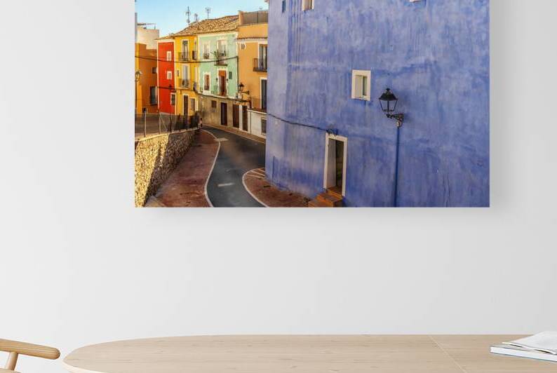 Narrow street of colourfully painted houses in Villajoyosa Cost by Kevin Hellon