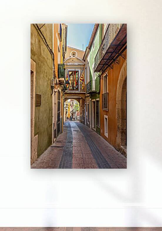 Narrow street of colourfully painted houses in Villajoyosa Cost by Kevin Hellon