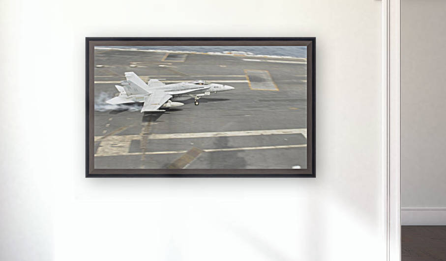 An F-A-18C Hornet lands on the flight deck of USS Nimitz. by StocktrekImages