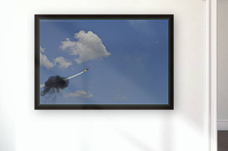 A Yakovlev Yak-55M aerobatic aircraft flys through a smoke ring. by StocktrekImages