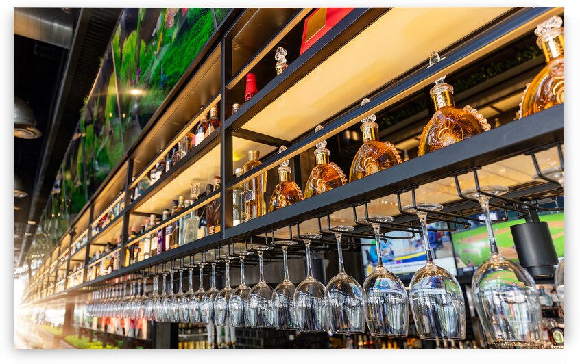 Miami Florida restaurant bar with a variety of wine and liquor bottles and glasses on the shelves by Elijah Lovkoff