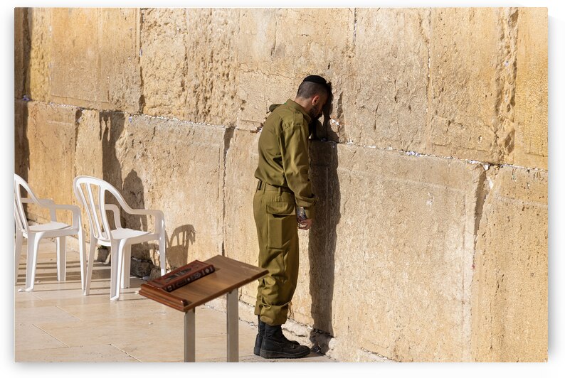 Israeli soldier praying in front of Sacred Western Wall in Jerusalem Old City Jewish Temple by Elijah Lovkoff