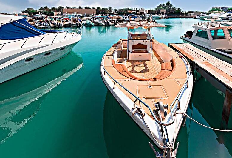 United Arab Emirates Abu Dhabi waterfront marina in downtown with yachts and water sport activity by Elijah Lovkoff