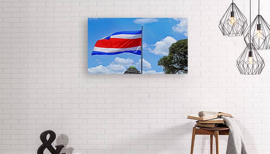 Costa Rica Flag proudly waving in San Jose. Large Costa Rica flag is flying high in city center by Elijah Lovkoff