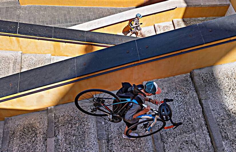 People carrying bicycle up the stairs in european city for recreation and sport activity by Elijah Lovkoff