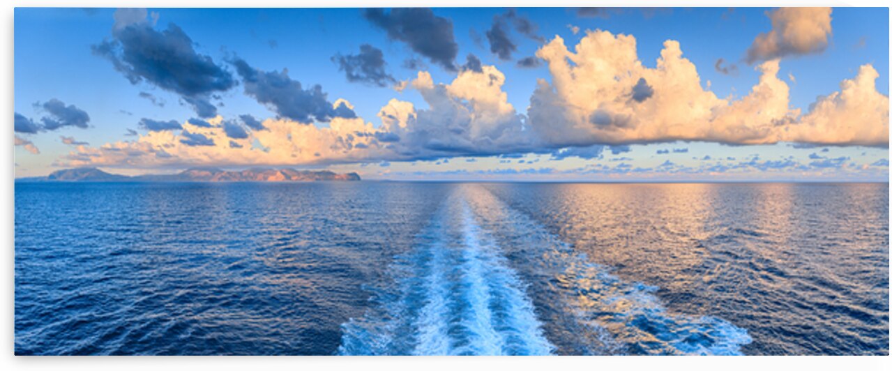 Sea horizon with orange clouds and ships wake.Panoramic view from the sea of ​​the Sicilian coast near Palermo southern Italy: the Capo Gallo Nature Reserve in the center. by Giuseppe Colasanto