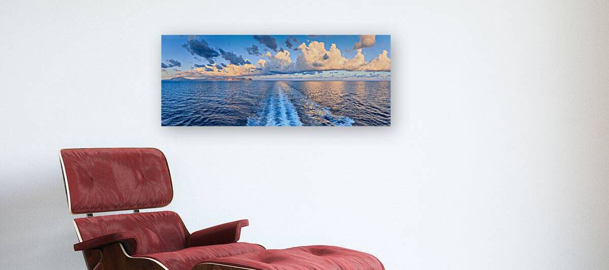 Sea horizon with orange clouds and ships wake.Panoramic view from the sea of ​​the Sicilian coast near Palermo southern Italy: the Capo Gallo Nature Reserve in the center. by Giuseppe Colasanto