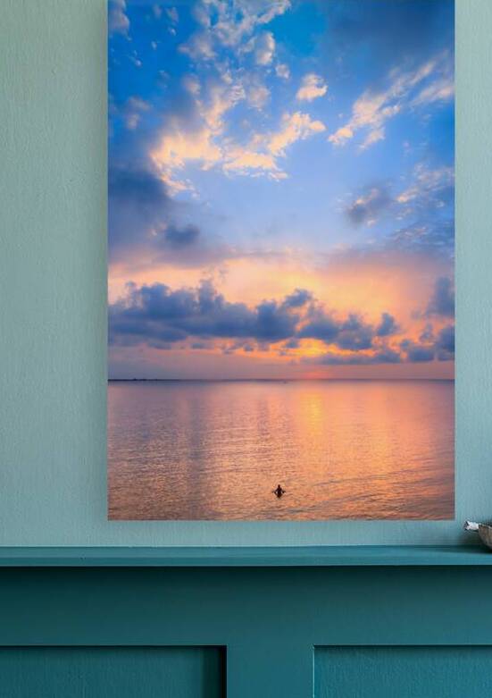 Relaxing by the sea at sunset. A man in the sea relaxes as he watches the sunset through the clouds. by Giuseppe Colasanto