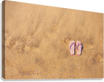 Flip flops on sand Canvas Print