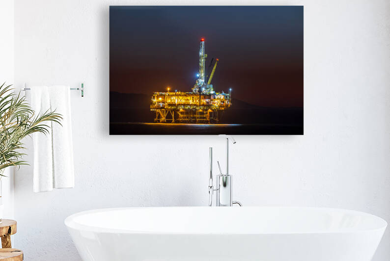 Lighted offshore oil platform at dusk by Joe Belanger