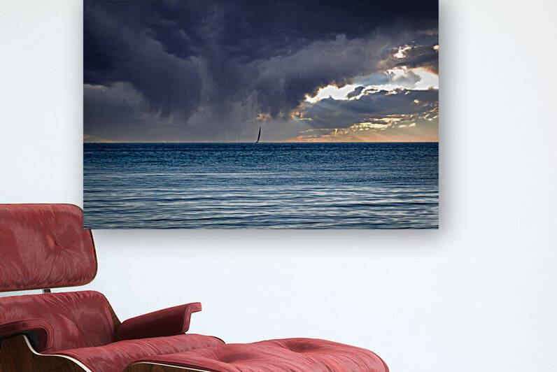Solitary sailing boat under grey clouds after a storm in the Mediterranean sea during winter by sergiopazorama