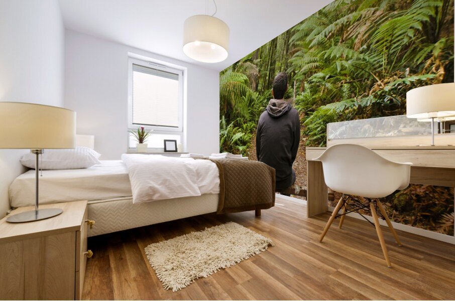 Travel man sitting in a green lush fern forest Mural print