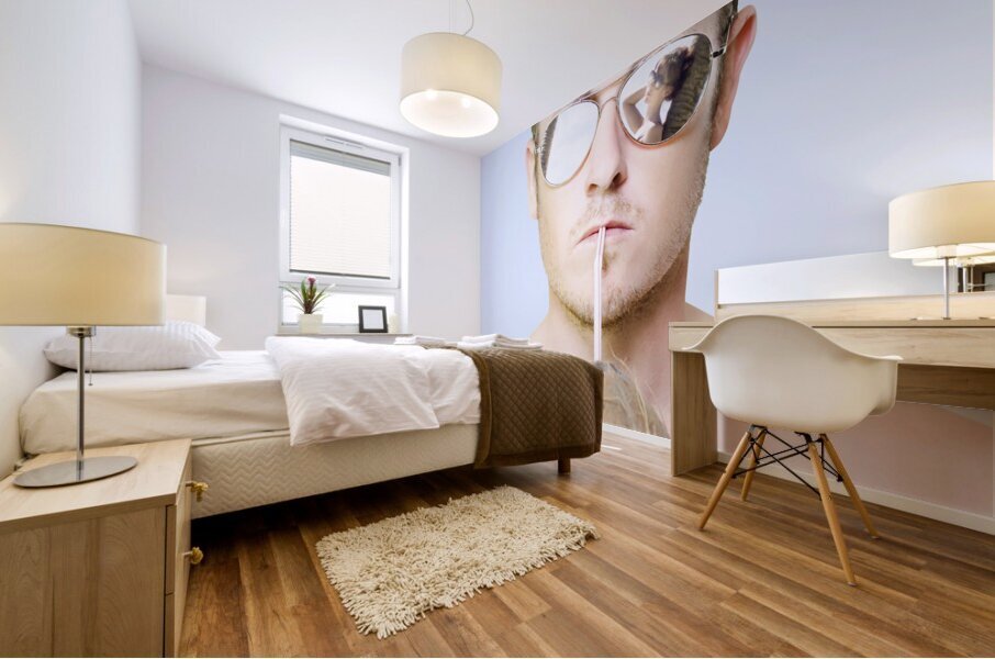 Handsome summer man drinking coconut cocktail Mural print