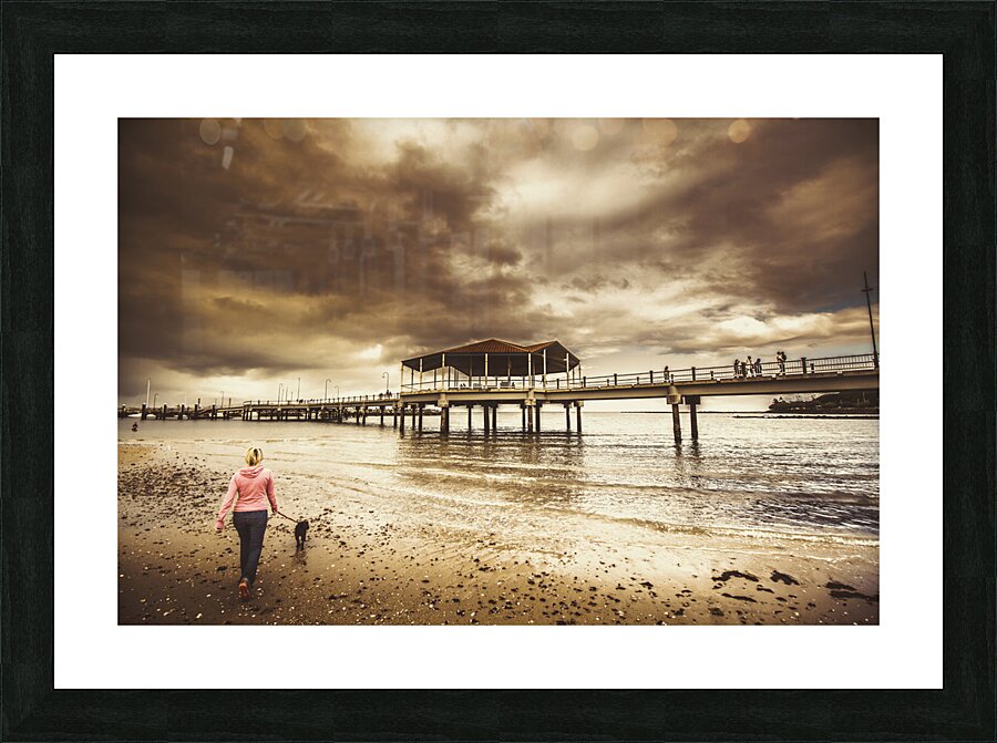 Woman walking dog on stormy beach Picture Frame print