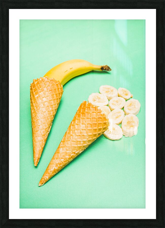 Whole bannana and slices placed in ice cream cone Picture Frame print