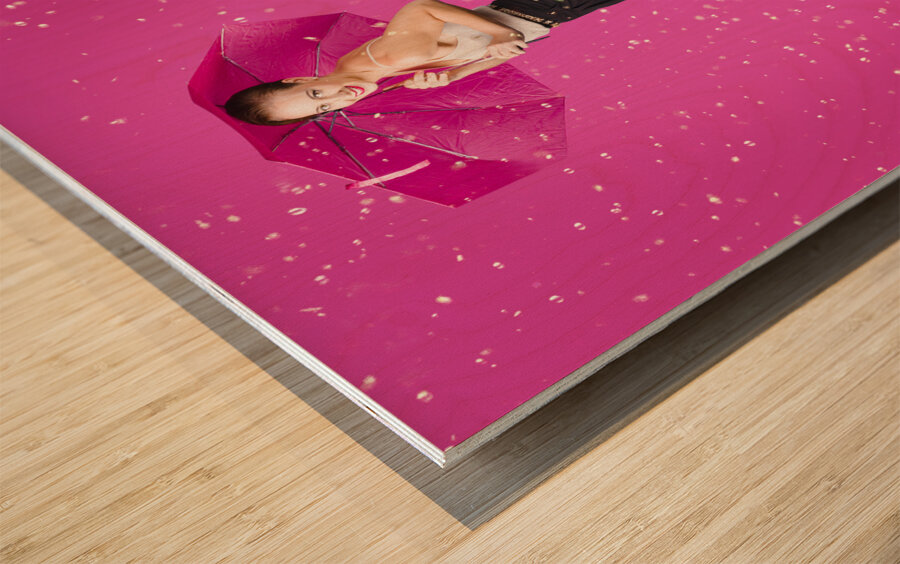 Smiling female model dancing in falling rain Wood print