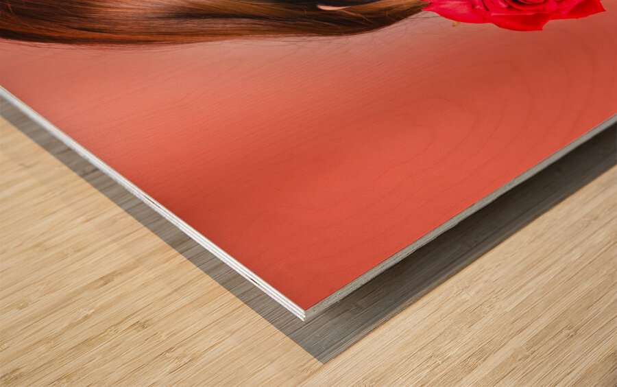 Woman gripping red rose between her teeth Wood print