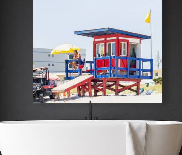 A lifeguard station on Cocoa beach with a man sit by Woodys Photos