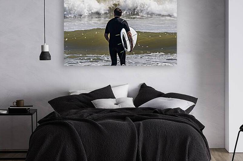 Rear view of man with a surfboard walking into the ocean by Woodys Photos