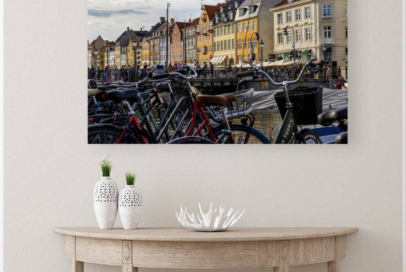 Bicycles Parked Along a Vibrant Canal in Copenhag by Woodys Photos
