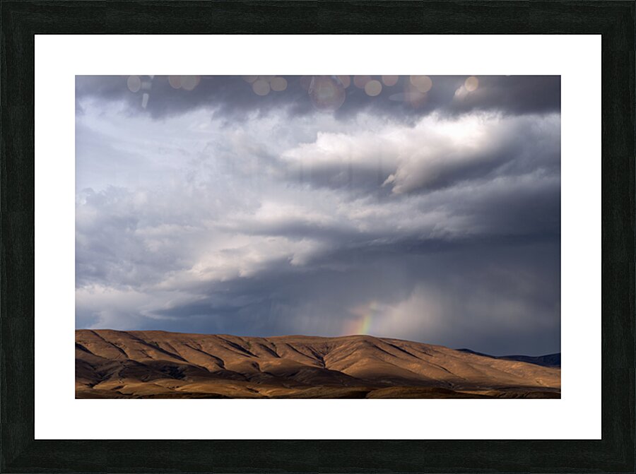 Rainbow with diagonal clouds over morning light on mountains Picture Frame print