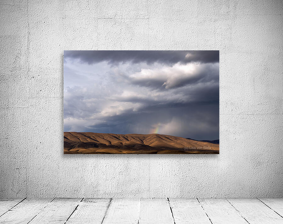 Rainbow with diagonal clouds over morning light on mountains Wall Preview