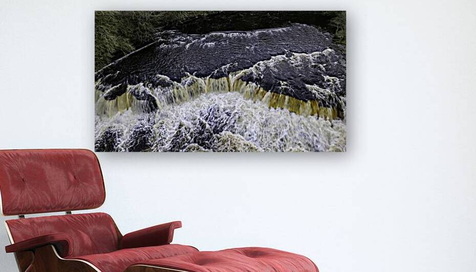 Rushing water cascades over a forested waterfall showcasing natures dynamic movement and power. by Vasile Jechiu