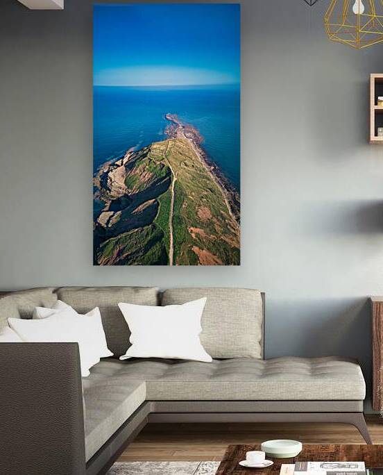 Aerial view of a scenic coastal landscape with a winding road leading to a headland against a blue ocean in Filey England. by Vasile Jechiu